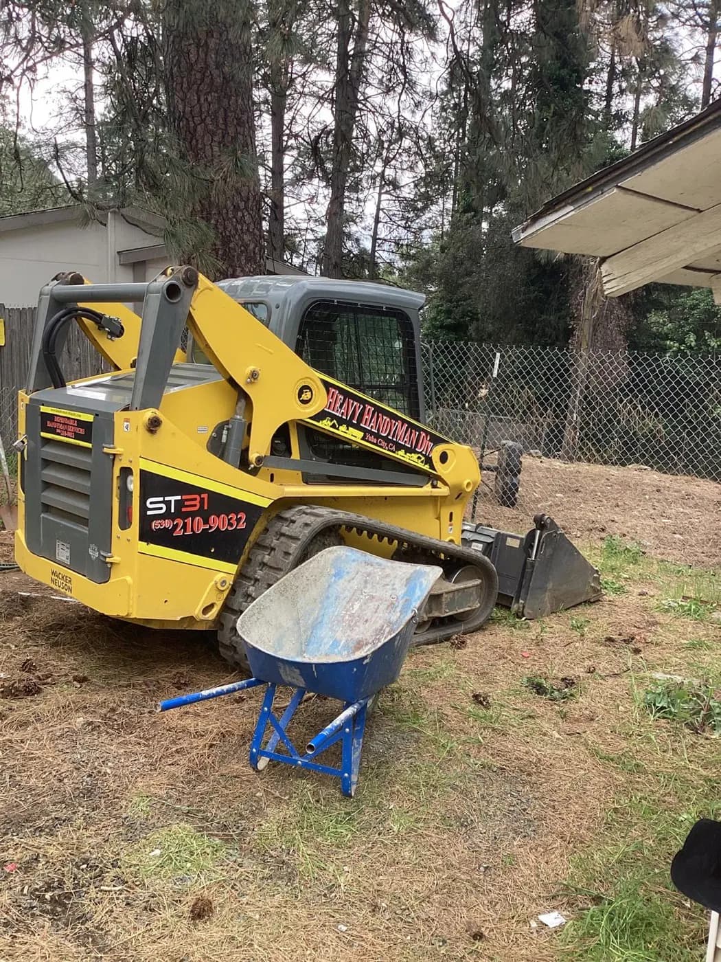 Perry's Landscaping skid steer on site with the company name on the boom
