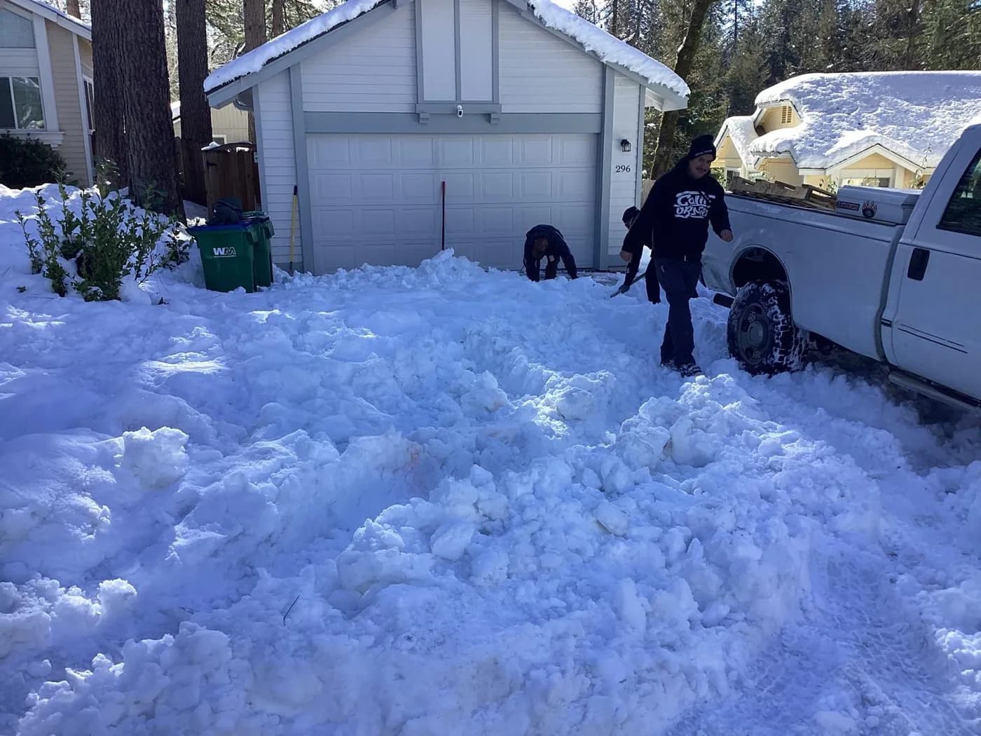 Driveway being cleared by hand after heavy snow at a foothill home