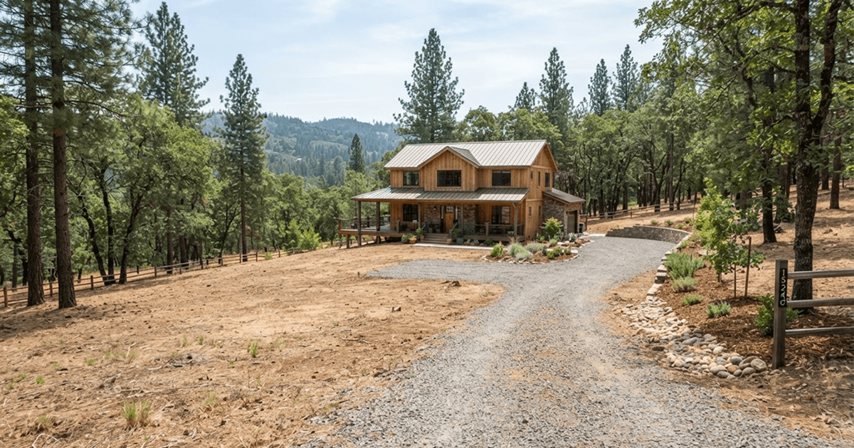 Completed defensible space clearing around a foothill home in Nevada County, CA, with thinned trees and open ground.